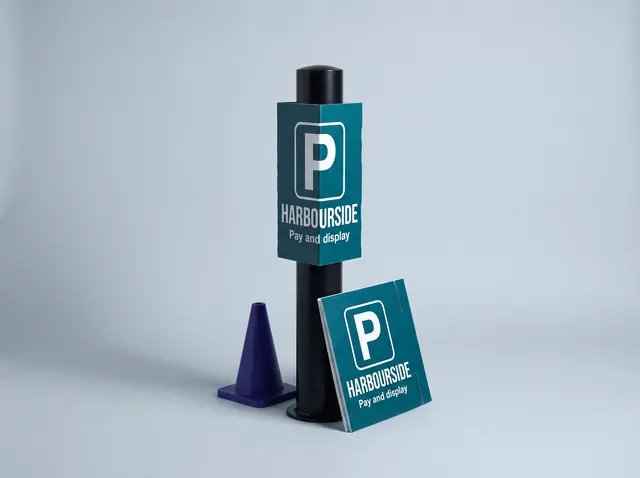 A teal Harbourside parking cover on a black bollard, with a spare beside it