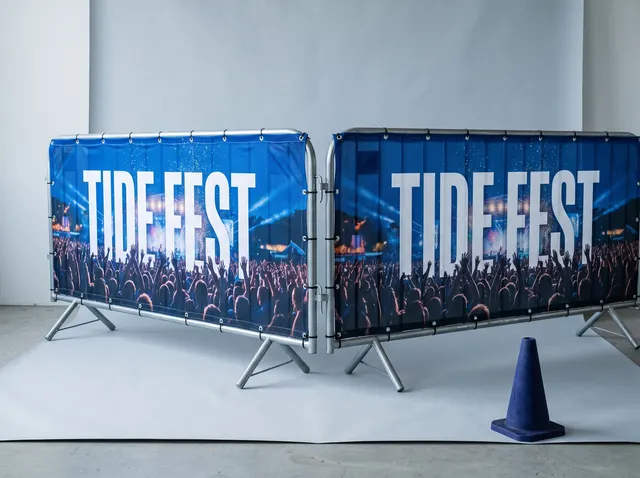 Two crowd barriers in blue Tide Fest covers showing a festival crowd