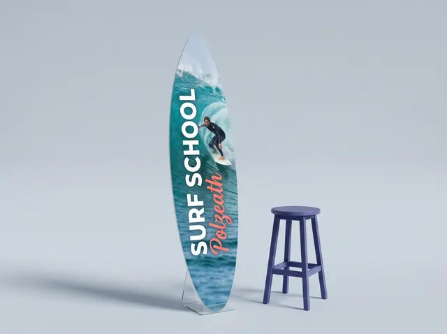 A surfboard-shaped Surf School sign showing a surfer on a turquoise wave
