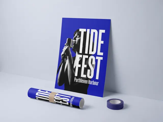 A blue Tide Fest poster with a singer in black and white, leaning against the wall beside a rolled copy