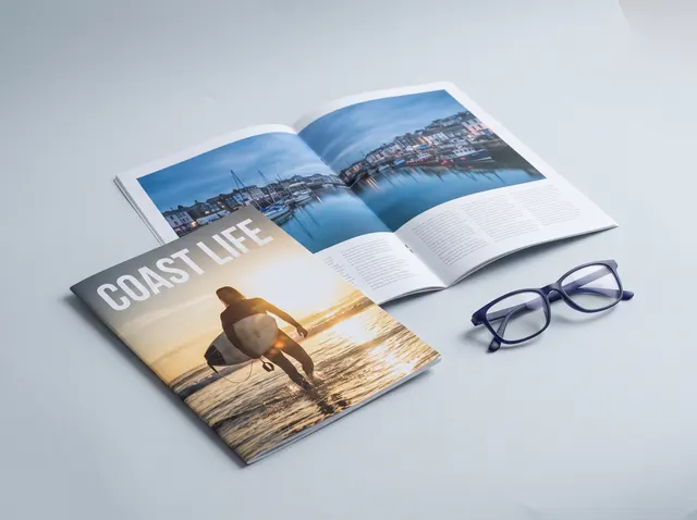 Coast Life magazines, one open at the centre spread showing the staples